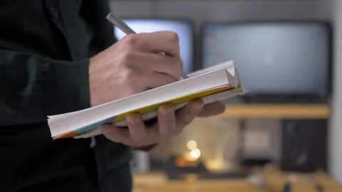 The man makes notes in a notebook and thinks about something. Stock Footage 129992026