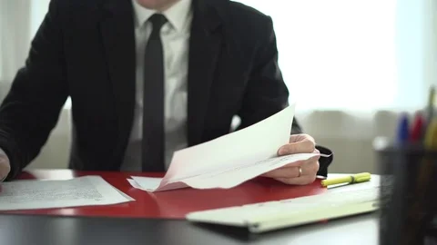 Man makes notes on paperwork at his desk Stock Footage 71628212
