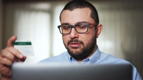 Man  makes online payments through the Internet from bank card Stock Footage 174186746