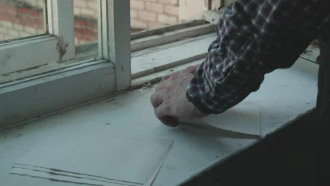 Man makes a paper airplane on a windowsill. Stock Footage 156849045