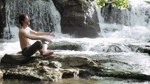 Man makes physical exercises to keep fit , near wonderful waterfalls Stock Footage 24770358
