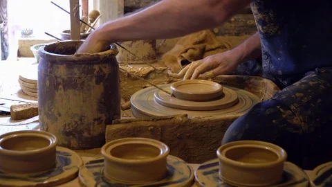A man makes a pitcher of clay on a Potter's wheel. Stock Footage 123852222