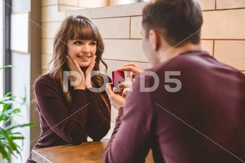 The man makes a proposal to his girlfriend in the restaurant Stock Photos