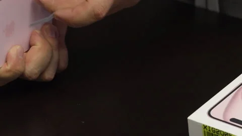 A man makes a protective glass installation for iPhone 15. Removes fixing s.. Stock Footage 277545722