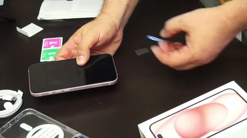 A man makes a protective glass installation for iPhone 15. Removes fixing s.. Stock Footage 277545724