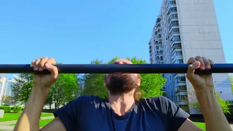 Man makes pull ups on the metal bar. Hard fitness, so tired, can do it? Stock Footage 155436739