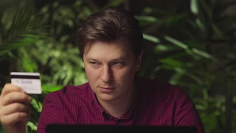 A man makes purchases using a laptop and a bank card Stock Footage 149029626