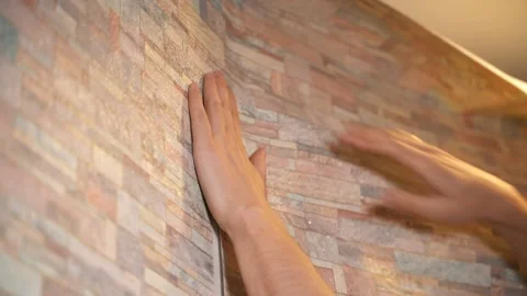 A man makes repairs in his house, neatly gluing wallpaper Vidéo 146041672