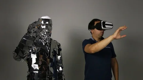 A man makes a robot copy his movements. Stock Footage 92946316