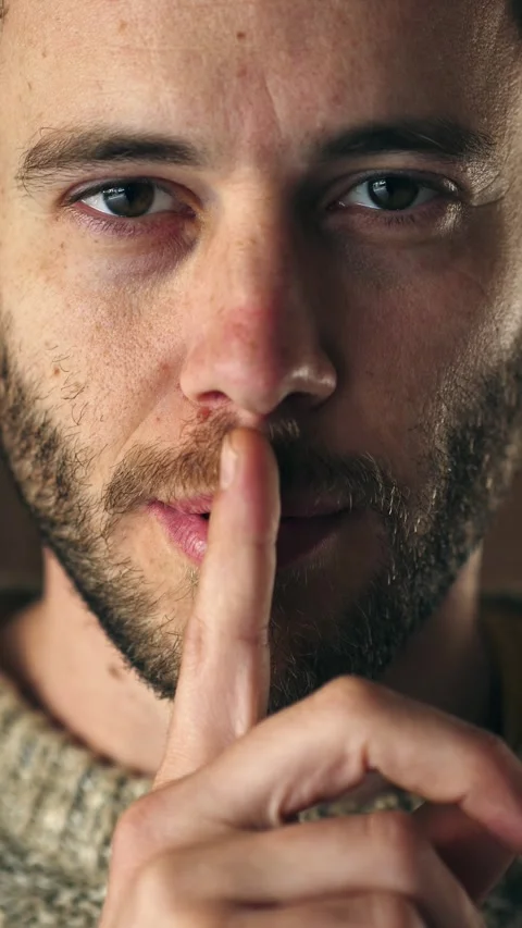 Man makes silence gesture in close-up shot Stock Footage 306680374