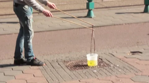 A man makes soap bubble on the street Stock Footage 57110460