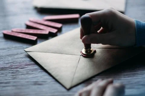 Man makes the stamp using sealing wax on the envelope Stock-Fotos