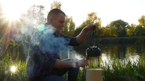 Man makes a tea on the fire Stock Footage 81768131