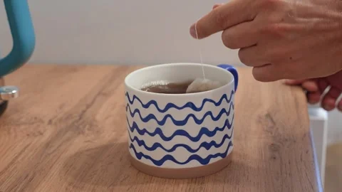 A man makes tea in a mug using a tea bag Stock Footage 318463608