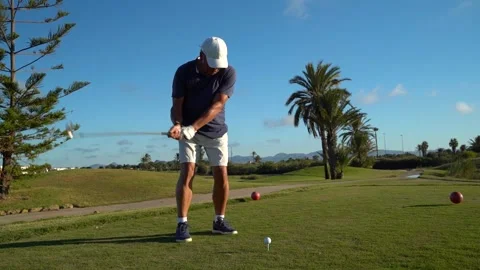 Man makes a test swing with a golf club on the grass of a golf club course... Stock Footage 252603882