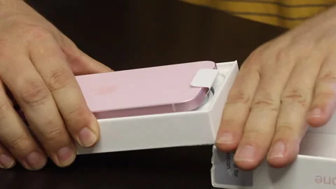A man makes the unpacking of a modern smartphone. It opens the box from the.. Stock Footage 277546476