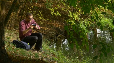 Man Makes Video Call Typing a Message Outdoors Watching Video Playing Virtual Stock Footage 68597540