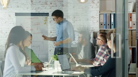 Man Makes Whiteboard Presentation to His Creative Office Staff.  Stock Footage 70852886
