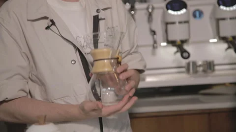 Man making alternative specialty filter coffee in pour over, brewing, minimal Stock Footage 234939108