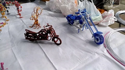 Man making and selling wirework models Stock Footage 72517563