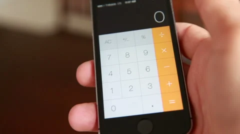 Man Is Making Arithmetic Operation With The Calculator Of The Smartphone Stock Footage 55551377