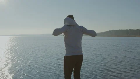 Man Is Making Arm Rotations On Lakeshore Stock Footage 166046033