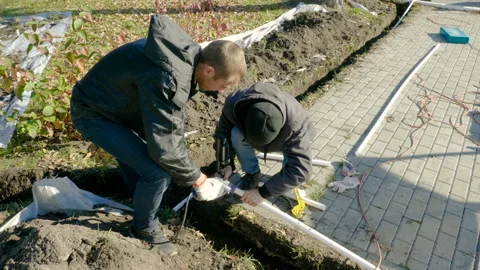 Man making an automatic system for watering plants and lawn in the garden. 4K 库存影片 106940145