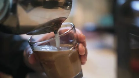 Man making beautiful latte art in glass cup. Coffee with pretty latte art Foam. 動画素材 334650348