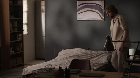 Man Making Bed in Bedroom during Morning Routine at Home Stock Footage 345513801