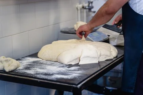 A man is making bread on a table Stock Photos