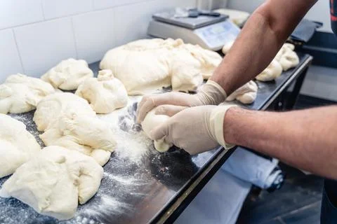 A man is making bread on a table Stock Photos