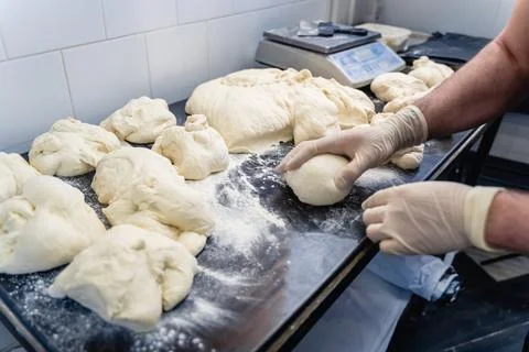A man is making bread on a table Stock Photos