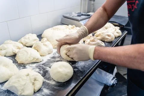 A man is making bread on a table Stock Photos