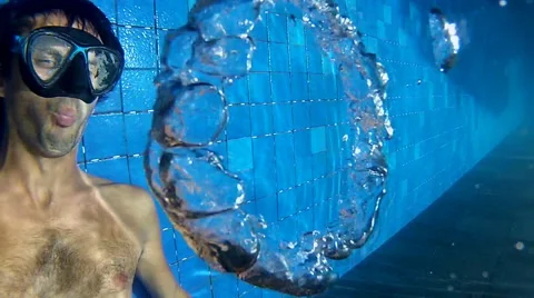 Man making bubble rings underwater in pool Stock Footage 59539479