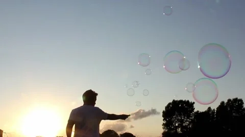 Man making bubbles, sun setting Stock Footage 40954335
