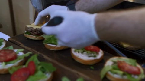 Man Making Burger Placing Tomatoes,Lettuce And Bread On Top Stock Footage 97794086