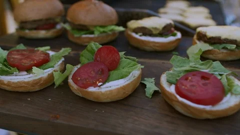 Man Making Burger Placing Tomatoes,Lettuce And Bread On Top Stock Footage 97794096