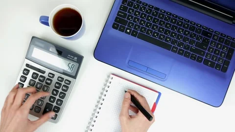 A man making calculations and taking notes in notebook at work Stock Footage 101752949