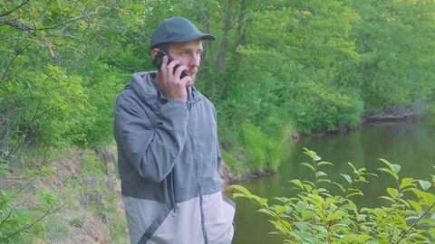 Man is Making a Call, Talking to Someone and Smiling, Clicks the Phone. Stock Footage 122466464