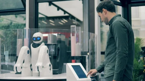 A man is making a coffee order and a robot is serving him Video stock 149473840