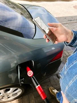 Man making contactless payment using smartphone for refueling car at gas st.. Stock-Fotos