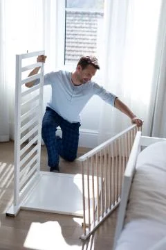 Man making cot in bedroom Stock Photos