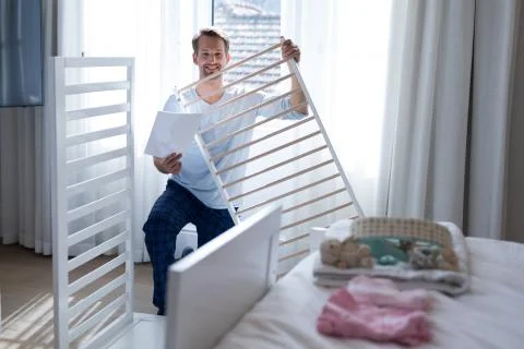 Man making cot in bedroom Stock Photos