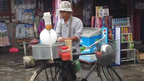 Man making cotton candy on a bicycle Stock Footage 105862664