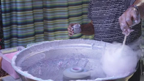 Man making cotton candy in a street market Stock Footage 250551861