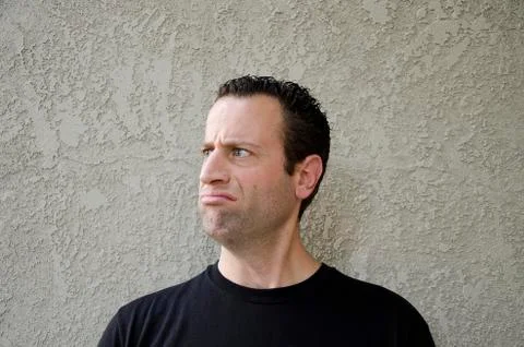 Man making a disgruntled face looking to the left. Stock Photos