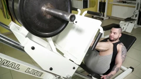 Man making exercises on the leg press in the gym Stock Footage 74136890