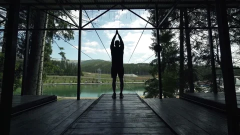 Man making exercises on a viewing mountains spot Stock Footage 200499030