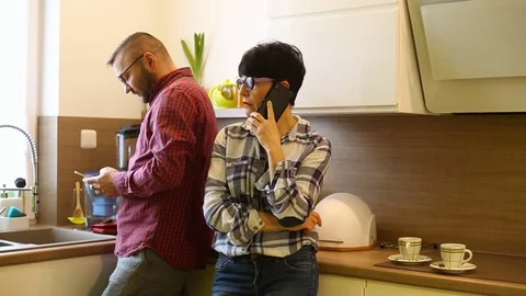 Man making faces and looks irritated while his girlfriend talks on cellphone Stock Footage 73305278