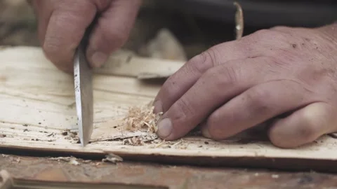 Man making fire tinder from birch bark with knife in the forest. Survival skills Stock Footage 280226670
